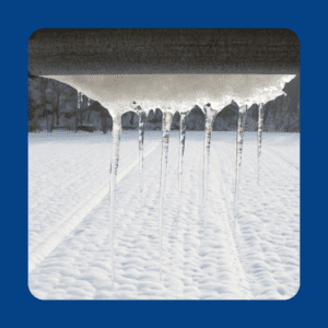 snow and icicles hanging from roof eaves 